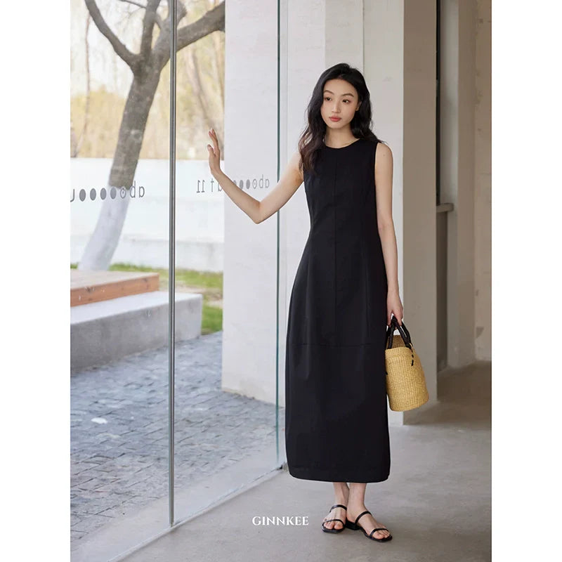 Sleeveless Maxi Dress Paired with a Woven Straw Handbag